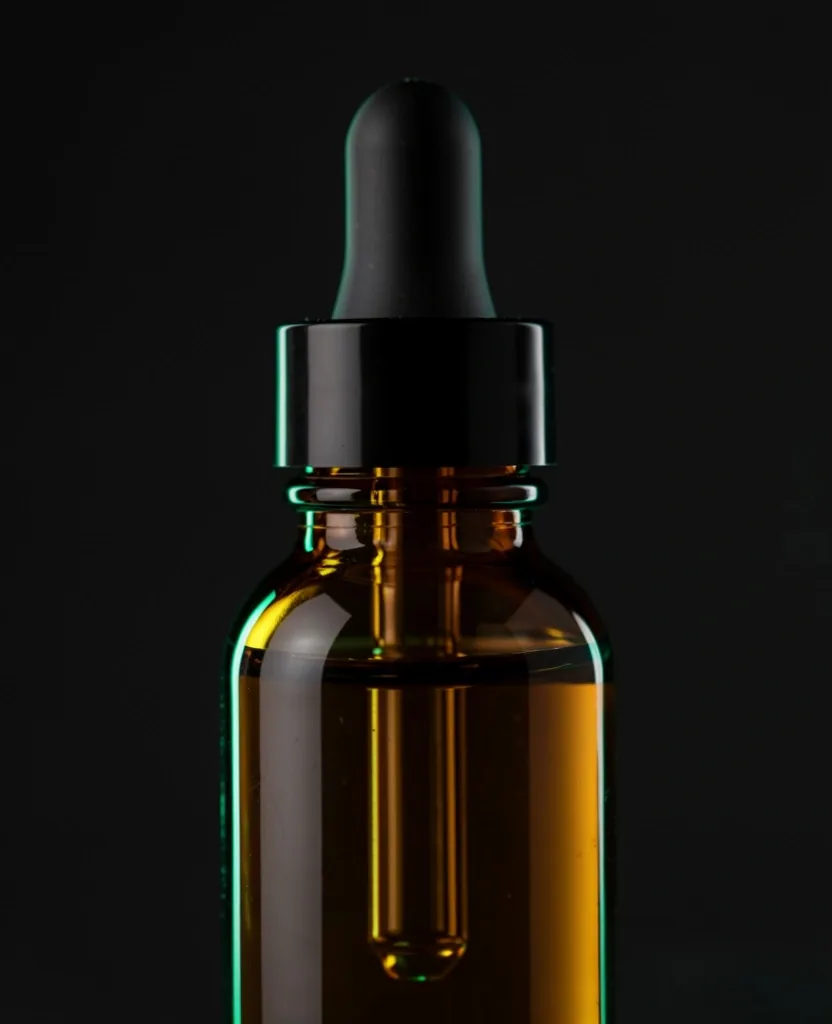 Natural supplement dropper bottle on a dark surface
